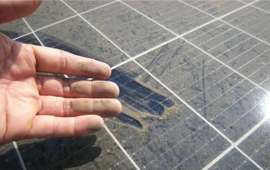 Mà mostrant la brutícia acumulada sobre una placa solar